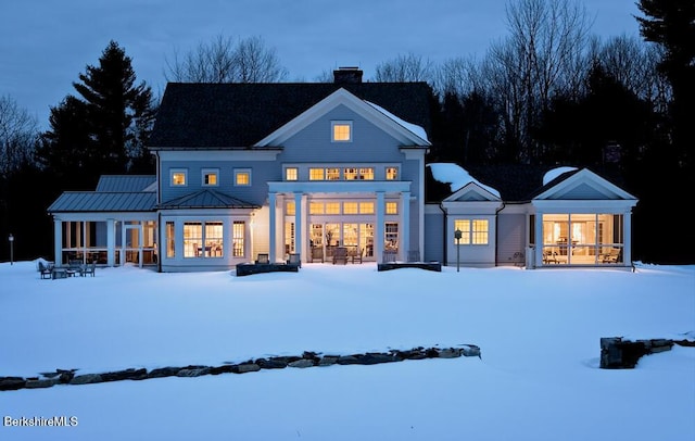 258 Sandisfield Rd, New Marlborough, MA 01230 - snow covered back of property featuring a sunroom, a chimney, and a standing seam roof