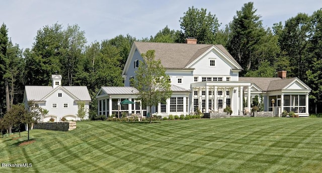 258 Sandisfield Rd, New Marlborough, MA 01230 - back of house featuring a sunroom, a chimney, a lawn, and metal roof