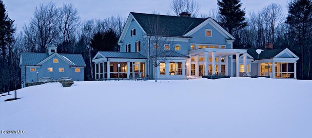 258 Sandisfield Rd, New Marlborough, MA 01230 - snow covered back of property with a sunroom, a chimney, and metal roof