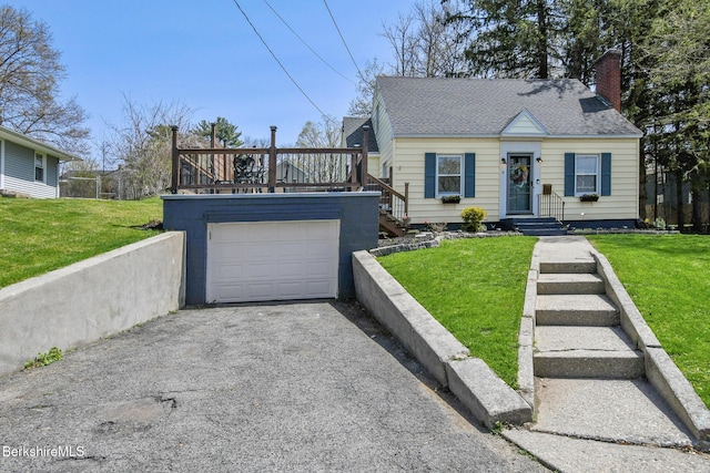 cape cod house featuring a front lawn, aphalt driveway, a wooden deck, roof with shingles, and a chimney