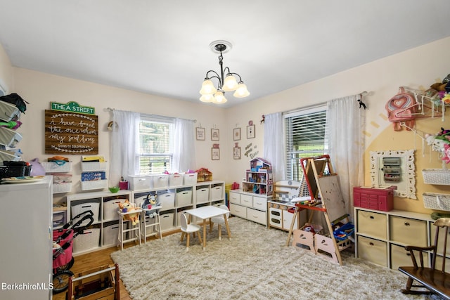 playroom featuring wood finished floors and a chandelier