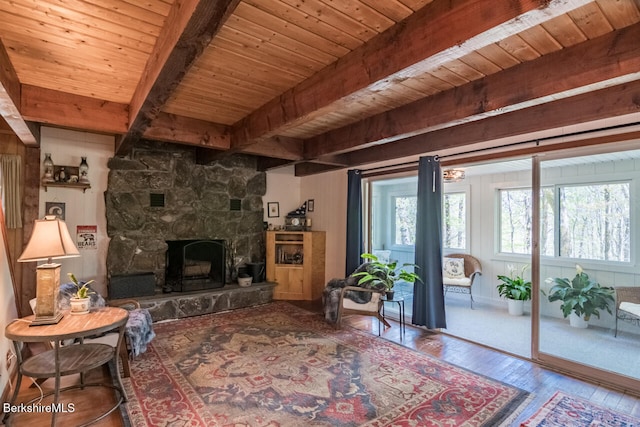 78 Slope Rd, Tolland, MA 01034 - living area with wood-type flooring, wooden ceiling with exposed beams, and a stone fireplace