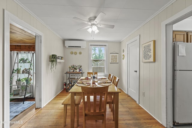 7 Chicopee St, Lanesborough, MA 01237 - dining area featuring crown molding, a wall mounted AC, ceiling fan, light wood-style floors, and wood walls