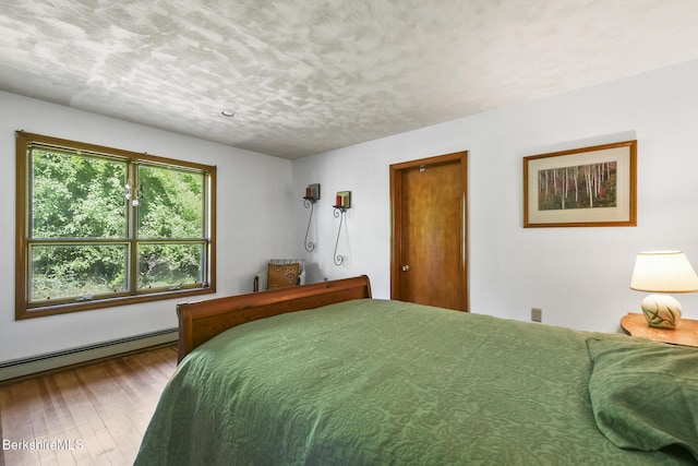 20 E Dugway Rd, Lenox, MA 01240 - bedroom featuring a baseboard heating unit, hardwood / wood-style flooring, and a textured ceiling