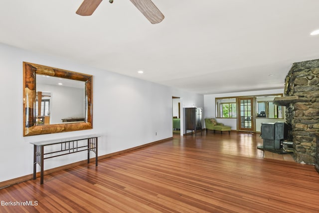 20 E Dugway Rd, Lenox, MA 01240 - unfurnished living room featuring a wood stove, ceiling fan, and wood finished floors