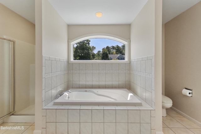 bathroom featuring a bath, a shower stall, toilet, and tile patterned floors