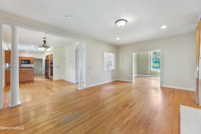 unfurnished living room with recessed lighting, ornate columns, baseboards, and light wood finished floors