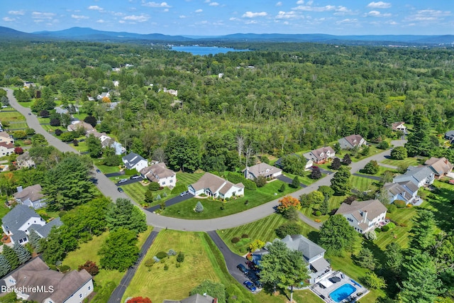 drone / aerial view with a residential view, a mountain view, and a forest view