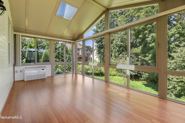 unfurnished sunroom with vaulted ceiling with skylight and a wall unit AC