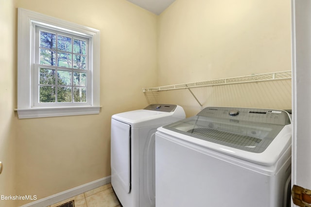 laundry area featuring laundry area, independent washer and dryer, light tile patterned flooring, and baseboards