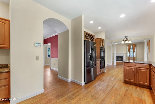 kitchen featuring light stone counters, brown cabinets, and stainless steel fridge with ice dispenser