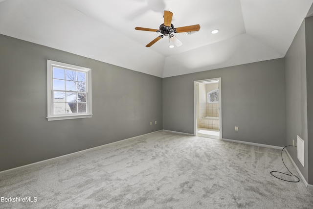 spare room featuring lofted ceiling, ceiling fan, light carpet, and baseboards