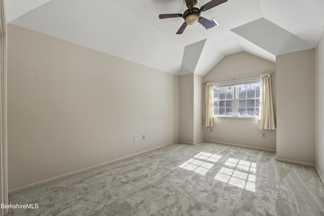 unfurnished room with lofted ceiling, light carpet, baseboards, and a ceiling fan