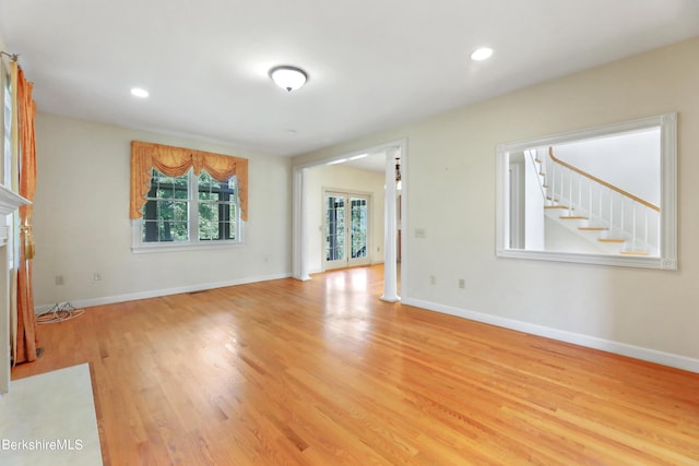 unfurnished living room featuring light wood-type flooring, baseboards, and recessed lighting