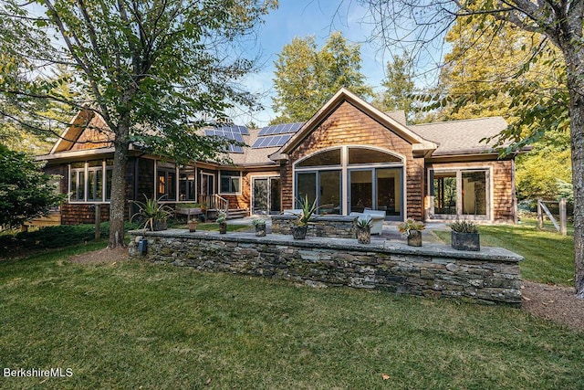 116 Brush Hill Rd, Great Barrington, MA 01230 - rear view of property featuring a patio area, solar panels, a yard, a shingled roof, and a sunroom