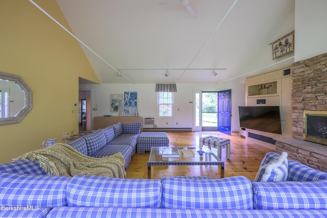 33 Interlaken Rd, Stockbridge, MA 01262 - living room with wood finished floors, track lighting, a stone fireplace, a baseboard radiator, and high vaulted ceiling
