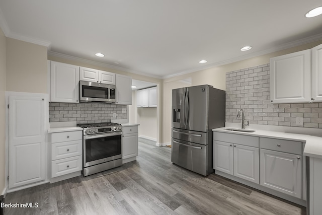 32 Hampshire St, Pittsfield, MA 01201 - kitchen with stainless steel appliances, light countertops, white cabinetry, crown molding, and backsplash
