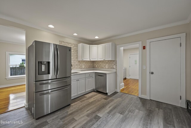32 Hampshire St, Pittsfield, MA 01201 - kitchen with stainless steel appliances, light countertops, dark wood-type flooring, white cabinets, and crown molding