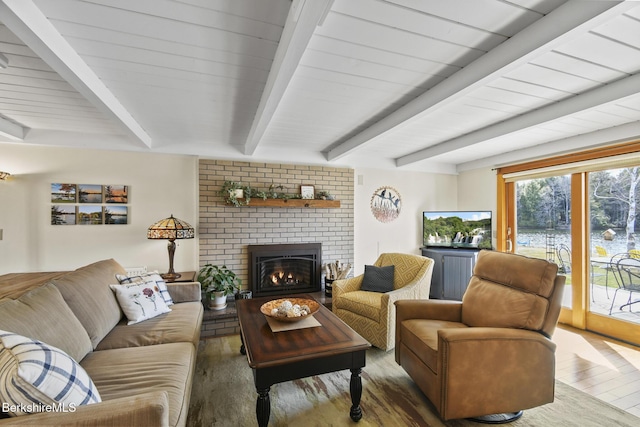 living area featuring a fireplace, wood finished floors, and beam ceiling