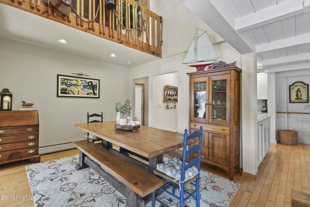 dining space featuring light wood-style flooring, recessed lighting, beam ceiling, and baseboard heating
