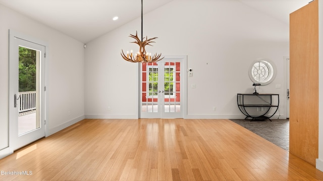 2017 Monterey Rd, Otis, MA 01253 - empty room with healthy amount of natural light, a chandelier, light wood-type flooring, french doors, and high vaulted ceiling