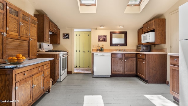51 Downs Rd, New Marlborough, MA 01230 - kitchen with white appliances, light wood-style floors, a skylight, and brown cabinetry