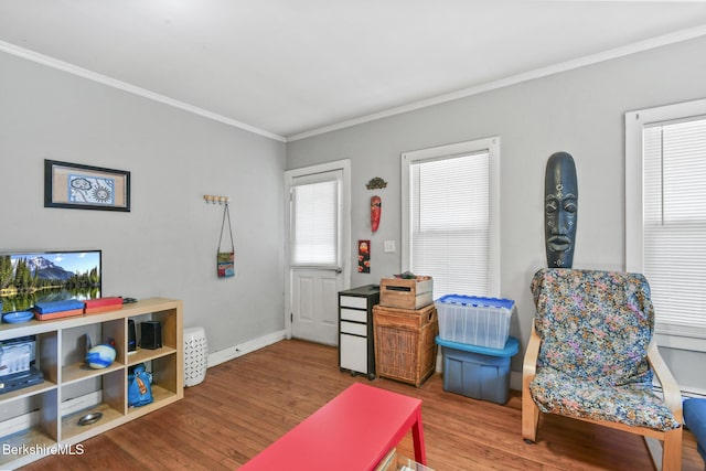 sitting room featuring crown molding, baseboards, and wood finished floors