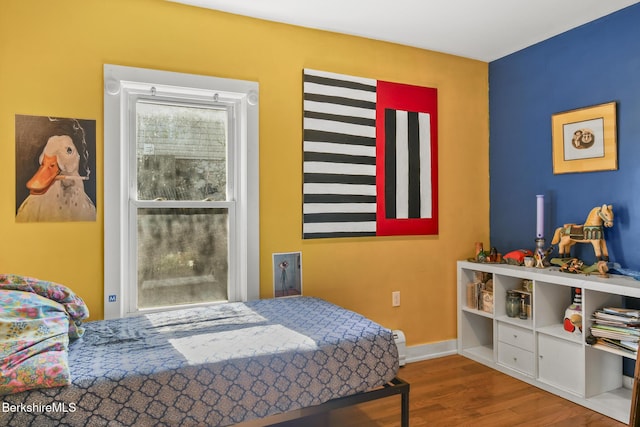 bedroom with baseboards and wood finished floors