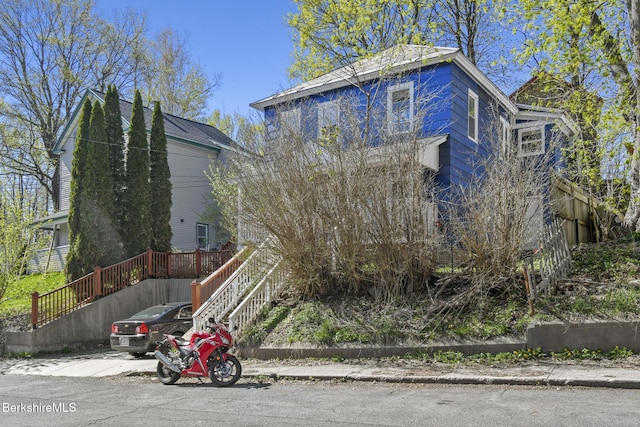 view of side of home featuring stairway