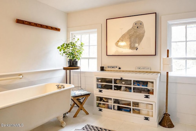 interior space featuring a tub, tile patterned flooring, and a healthy amount of sunlight