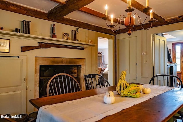 dining room featuring a chandelier and beamed ceiling