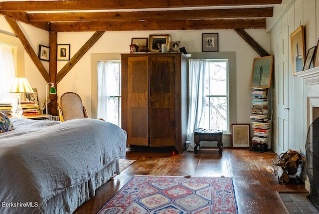 bedroom with multiple windows, dark hardwood / wood-style flooring, and beamed ceiling