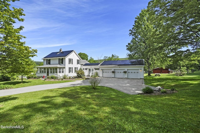 288 Johnson Rd, Dalton, MA 01226 - view of front facade with asphalt driveway, an attached garage, roof mounted solar panels, and a front lawn