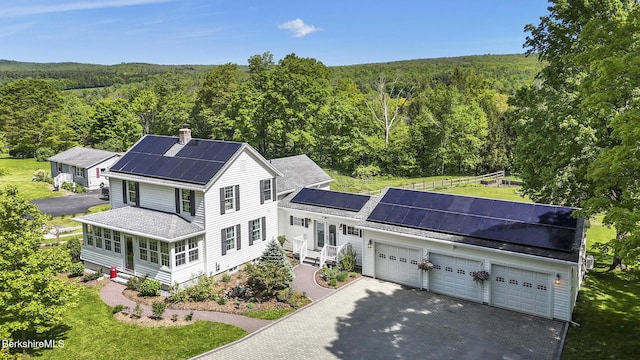 288 Johnson Rd, Dalton, MA 01226 - view of front of property with a forest view, an attached garage, roof mounted solar panels, and driveway
