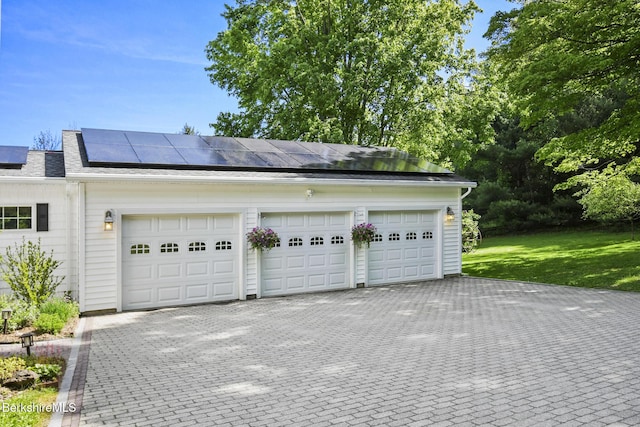 288 Johnson Rd, Dalton, MA 01226 - garage featuring roof mounted solar panels and decorative driveway