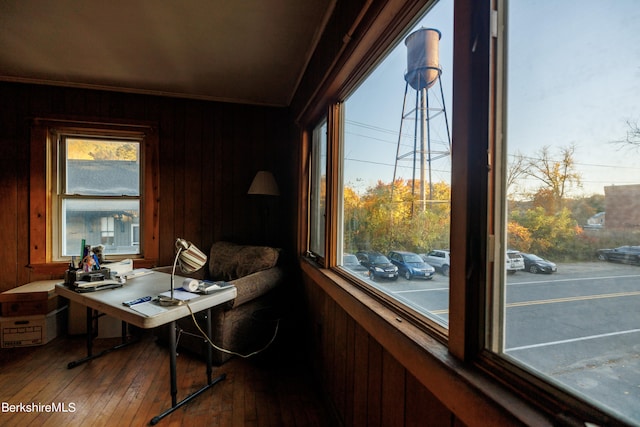 office space with hardwood / wood-style floors, wood walls, crown molding, and plenty of natural light