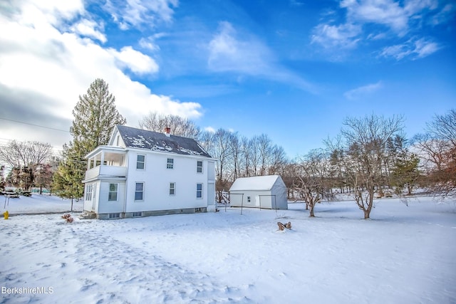 snow covered property featuring an outdoor structure