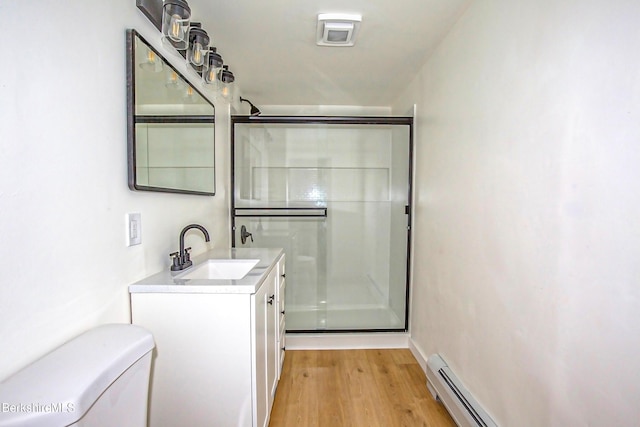 bathroom featuring vanity, baseboard heating, wood-type flooring, toilet, and a shower with shower door