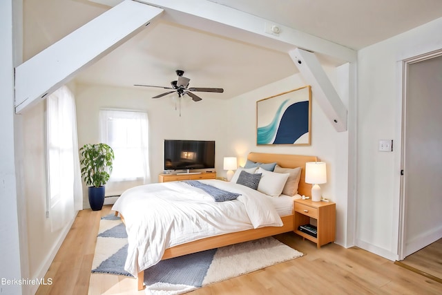 bedroom with beamed ceiling, ceiling fan, light hardwood / wood-style floors, and a baseboard radiator