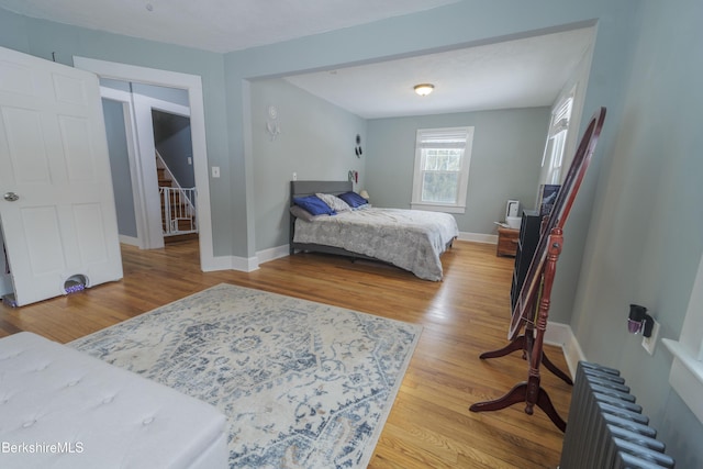 bedroom with light hardwood / wood-style floors and radiator