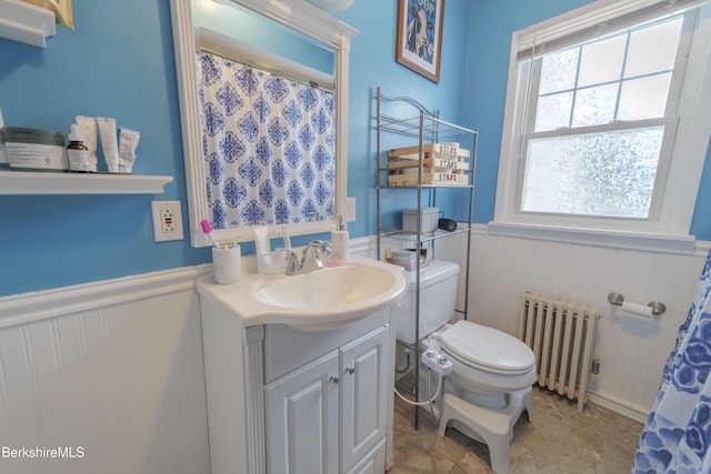 bathroom featuring vanity, toilet, and radiator heating unit