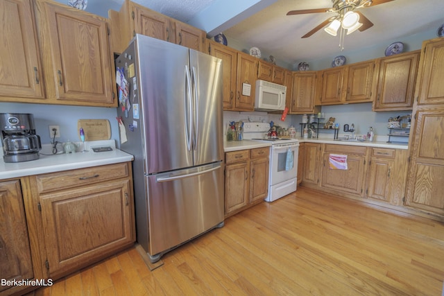 kitchen featuring ceiling fan, light wood-type flooring, and white appliances