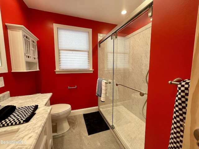 bathroom with vanity, a shower with shower door, and toilet