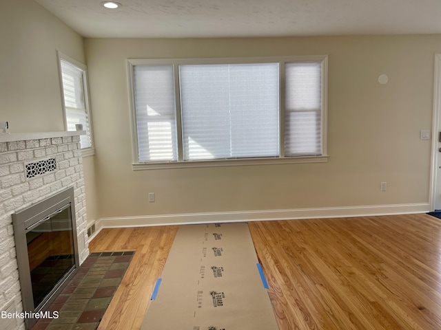 unfurnished living room featuring a fireplace and light wood-type flooring