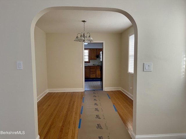 unfurnished dining area with a chandelier and hardwood / wood-style flooring