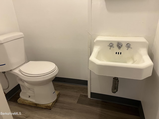 bathroom featuring wood-type flooring, sink, and toilet