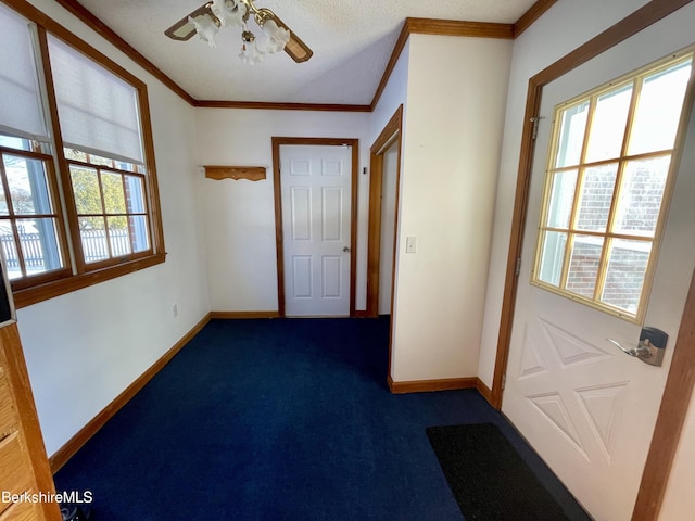 doorway to outside with dark colored carpet, ceiling fan, and crown molding