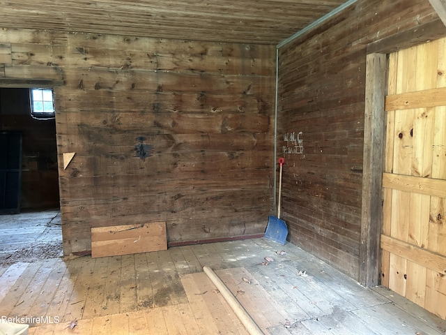 unfurnished room featuring hardwood / wood-style floors, wooden walls, and wood ceiling