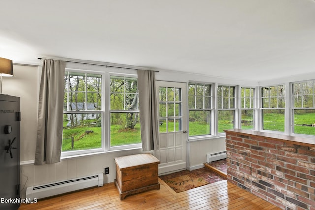 sunroom featuring baseboard heating and wood-type flooring