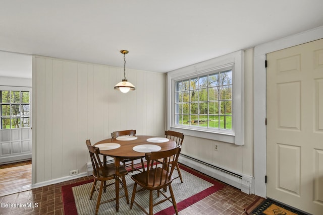 dining area with baseboard heating, brick patterned flooring, and baseboards